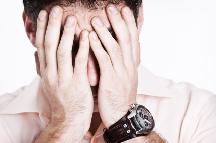 man  hiding  his face in his hands